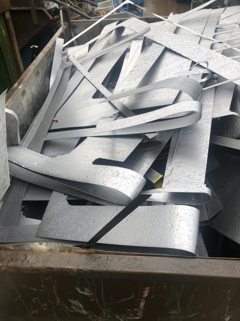 Thin sheets of stainless steel metal scrap in a skip