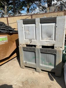 Two stacked containers next to Spire Metals branded scrap collection skip