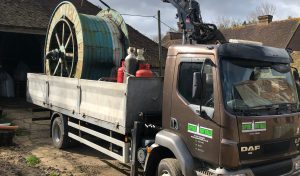Close up image of Spire Metals truck lifting up a large wheel from a rural mill